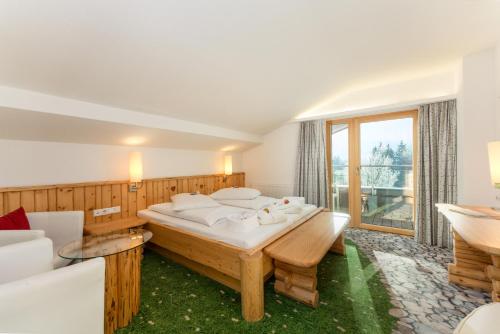 a bedroom with a large bed and a large window at Hartweger's Hotel in Haus im Ennstal