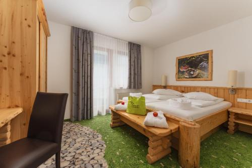 a bedroom with two beds and a chair in it at Hartweger's Hotel in Haus im Ennstal