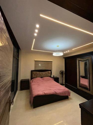 a bedroom with a bed with a pink blanket at سبانا شاليه in Jerash
