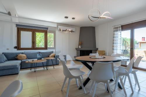 a living room with a blue couch and a table and chairs at Atalaya Villa in Stalís