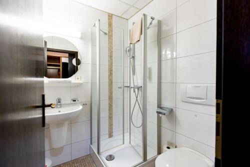 ein Badezimmer mit Dusche, Toilette und Waschbecken in der Unterkunft Hotel Alter Kranen in Würzburg
