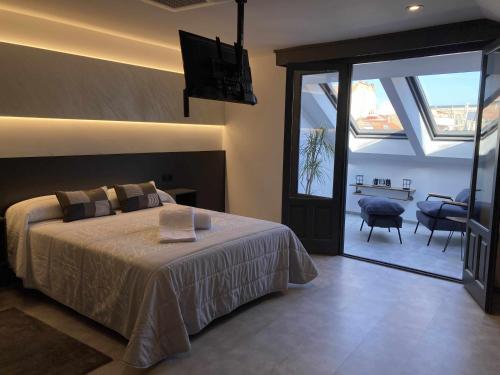 a bedroom with a bed and a sliding glass door at La Aduana - The Lodging Experience in Astorga