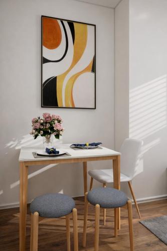 a dining room table with two chairs and a painting at Urban Bloomsbury Hideaway in London