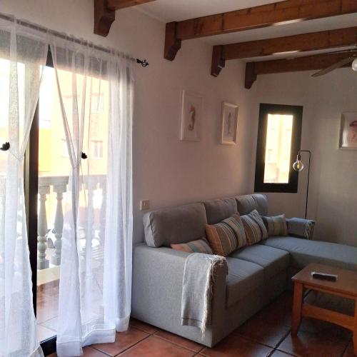 a living room with a couch and a window at Sun Home Arinaga in Arinaga
