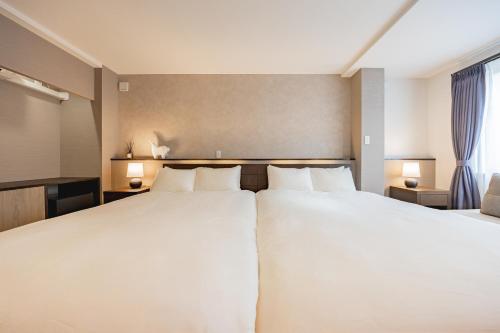 a hotel room with two beds and two lamps at The Mita Villa - 2 bed rooms & 3 floors villa with roof garden in Tokyo