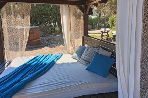a bed in a gazebo with blue pillows at La Casita - Boutique Retreat Barcelona Coast Sea View in Sant Andreu de Llavaneres