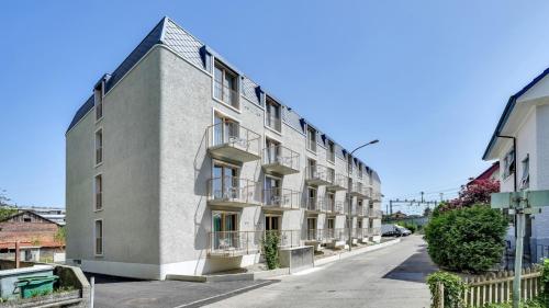 an apartment building with balconies on a street at MOOI Apartments Biel in Biel
