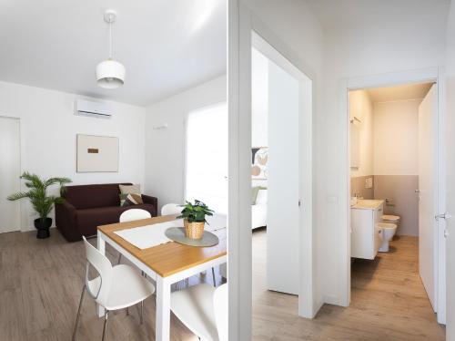 a white apartment with a dining table and a living room at Maison Bellini 4 in Toscolano Maderno