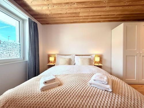 a bedroom with a bed with two towels on it at Modernes Apartment - Lakeview Sunnmatte in Leissigen