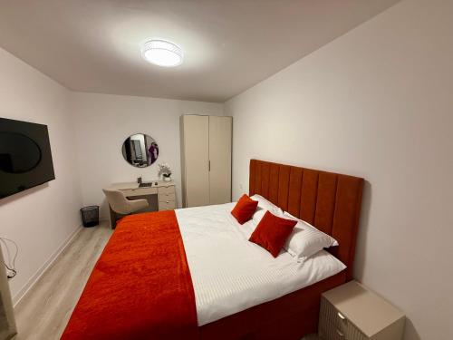 a bedroom with a bed with a red and white blanket at IDDA Concept 4 in Târgu-Mureş