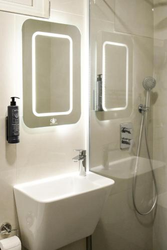 a white bathroom with a sink and a shower at Hotel Ipek Palas in Istanbul