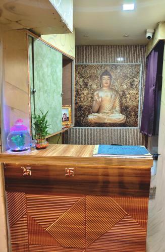a room with a large painting of a buddha on the wall at Hotel Heavens in Dum-Dum Junction