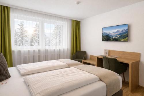 a hotel room with a bed and a desk and a table at Seelos - Alpine Easy Stay - Bed & Breakfast in Mieming