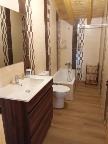 a bathroom with a sink and a toilet and a tub at Casa Abuela Antolina in La Horcajada