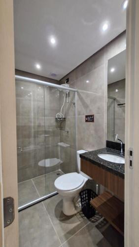 a bathroom with a toilet and a shower and a sink at Nexus Conceição in São Paulo