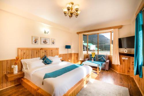 a bedroom with a large bed and a tv at Manali Golden Valley in Manāli