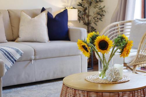 a living room with a vase of sunflowers on a table at The Nook - Cosy coastal retreat near Sandbanks in Poole