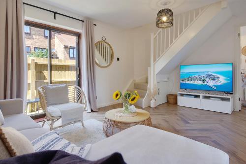 a living room with a couch and a tv at The Nook - Cosy coastal retreat near Sandbanks in Poole