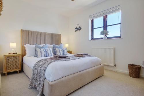 a bedroom with a large white bed with a window at The Nook - Cosy coastal retreat near Sandbanks in Poole