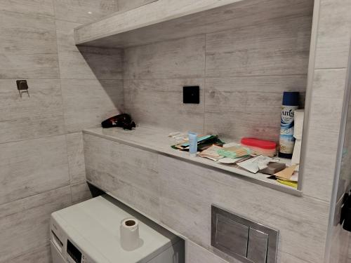 a bathroom with a toilet and a shelf with items on it at SAS Militaria dla 2 par 2 pokoje 4 osobysamodzielne zameldowanie, kody w wiadomości przed przyjazdem in Borne Sulinowo
