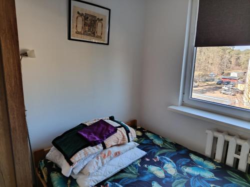 a bed with pillows on it in a room with a window at SAS Militaria dla 2 par 2 pokoje 4 osobysamodzielne zameldowanie, kody w wiadomości przed przyjazdem in Borne Sulinowo