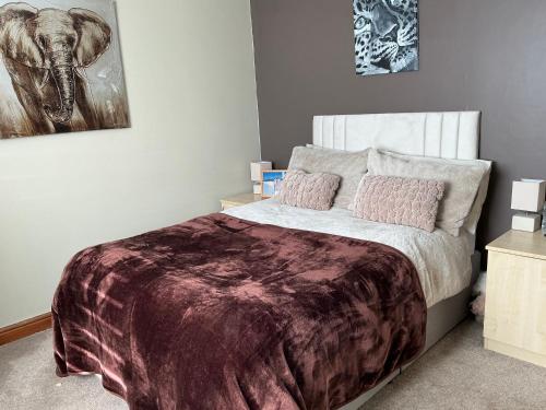 a bedroom with a bed and a painting of an elephant at Cozy Room at Willow House in Leyland