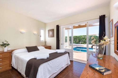 a bedroom with a bed and a view of a pool at Villa Las Rosas by Villa Plus in S'Algar