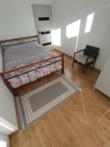 a small bedroom with a bed and a chair at Nowoczesny Apartament 400 M Od Plaży Prywatny Ogródek Ełk in Ełk