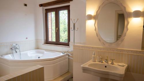 a bathroom with a tub and a sink and a mirror at Città della Pieve Retreat in Città della Pieve