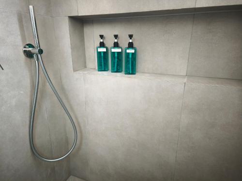 three bottles on a shelf in a bathroom at Villa Oneiron in Anavyssos