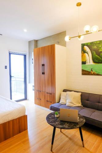 a living room with a couch and a laptop on a table at Chill Studio w Balcony & Free Pool Lapu-Lapu in Mactan Island