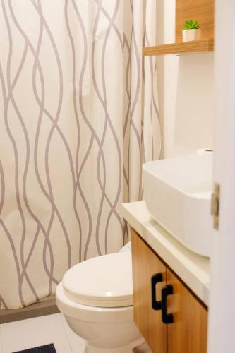 a bathroom with a toilet and a sink at Chill Studio w Balcony & Free Pool Lapu-Lapu in Mactan Island