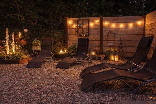 two chairs and a table in a yard with lights at Ferienhaus Haus im Garten in Feldkirch