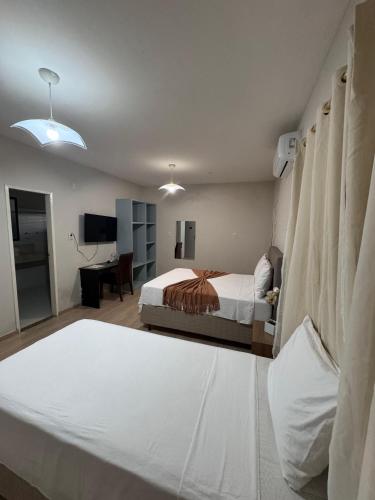 a hotel room with two beds and a desk at Pousada Du Porto in Macau