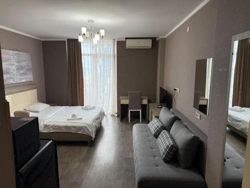 a hotel room with a bed and a couch at ORBI 4 Seasons ApartHotel in Batumi