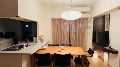 a kitchen and dining room with a wooden table and chairs at 青葉邸 AOZORA 1002 Near Dotonbori 3LDK 2 Bath 2 WC Premium Tower Residence in Osaka