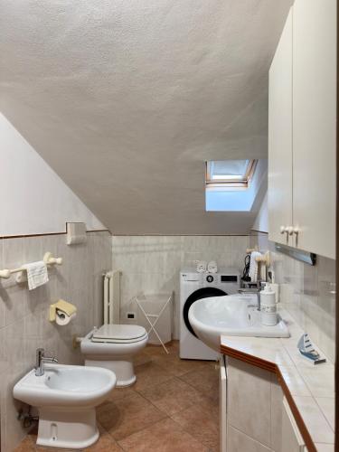 a bathroom with two sinks and a toilet and a window at Sole & Mare in Montesilvano