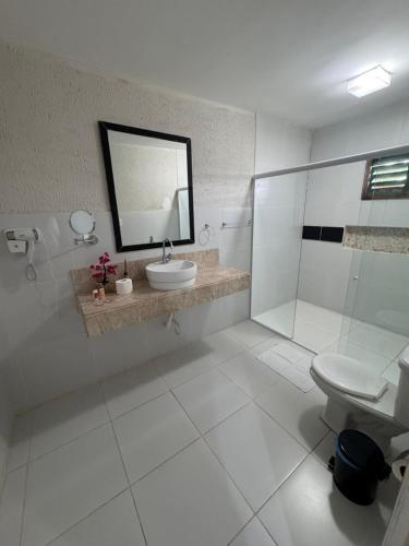 a bathroom with a sink and a toilet and a mirror at Pousada Du Porto in Macau