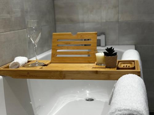 a bath tub with a wooden tray on top of it at Holdsworth House Apartments in Killingbeck