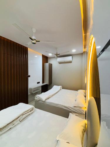 a bedroom with two beds and a mirror at Hotel RK in Ujjain