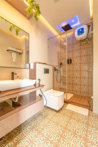 a bathroom with a sink and a toilet and a shower at Lakeside Leisure A Lake View Hotel in Udaipur