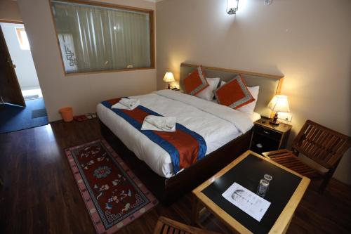 a bedroom with a large bed and a table with a drawer at Hotel Latso Ladakh in Leh