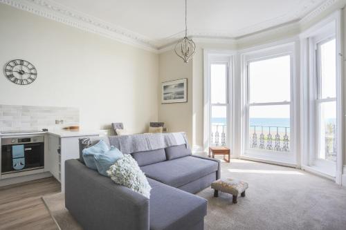 a living room with a couch and some windows at Seaways Apartment in Worthing