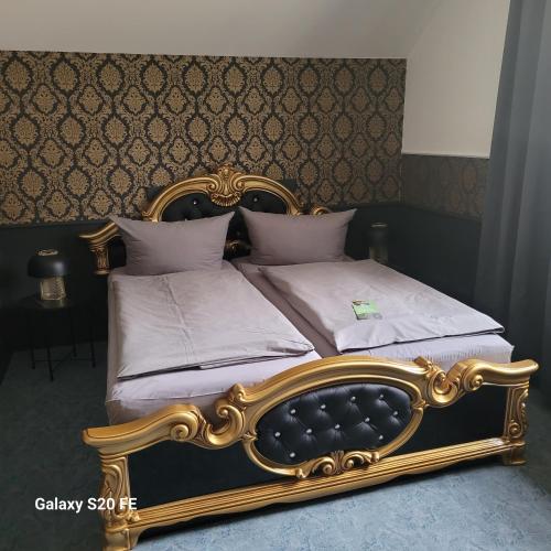 a gold bed with white sheets and pillows at Parkhotel Schwedt in Schwedt