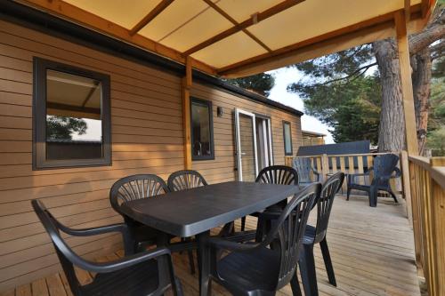 a black table and chairs on a deck at Vertacoflav - Bungalow - 6 couchages in Carry-le-Rouet