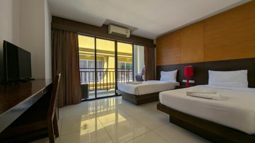 a hotel room with two beds and a balcony at Diamond Crown Patong in Patong Beach