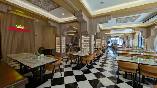 a restaurant with tables and chairs and a checkered floor at Diamond Crown Patong in Patong Beach