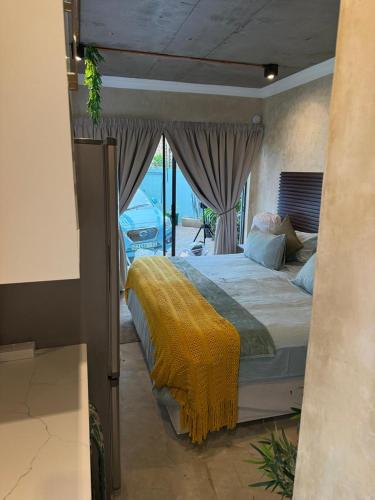 a bedroom with a bed with a yellow blanket on it at Falcons Rest in Pretoria