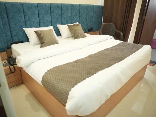 a bedroom with a large bed with white sheets and pillows at The RaaS Guestline in Noida