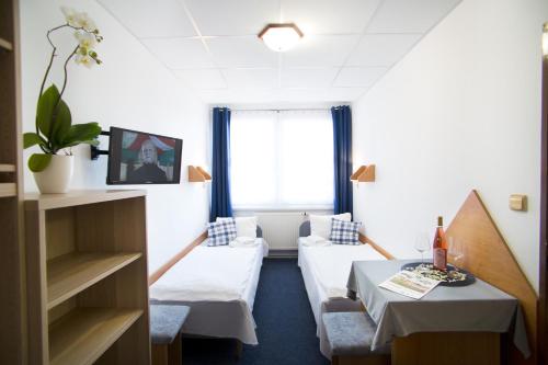 a hotel room with two beds and a table at Resort Kovács in Novosedly